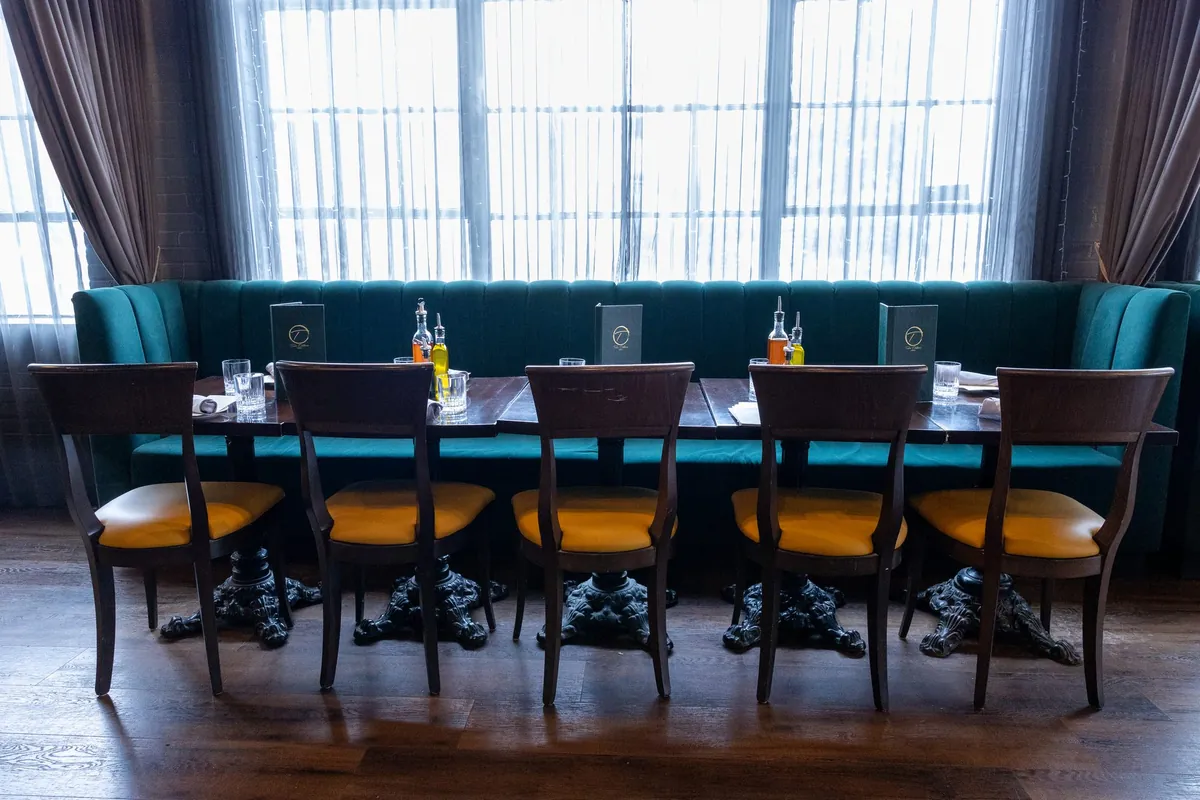 Emerald banquette seating by the windows at Tulia Osteria