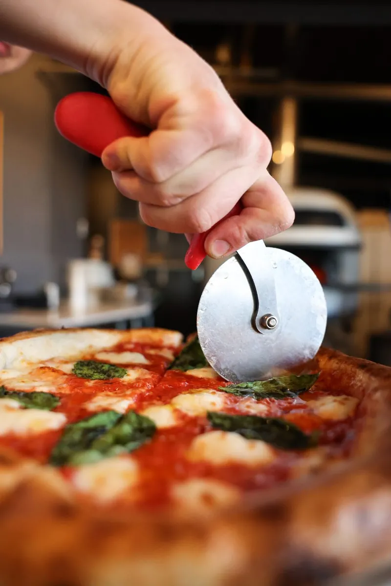 A margherita pizza cut fresh from the wood oven